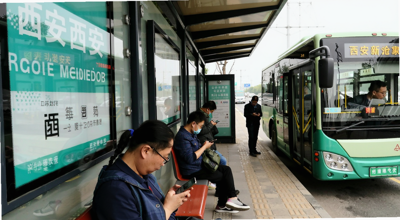西安公交站台乘客查看手机等车场景图