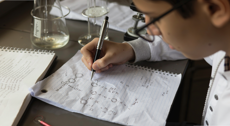 学生在草稿纸上验算化学方程式配平